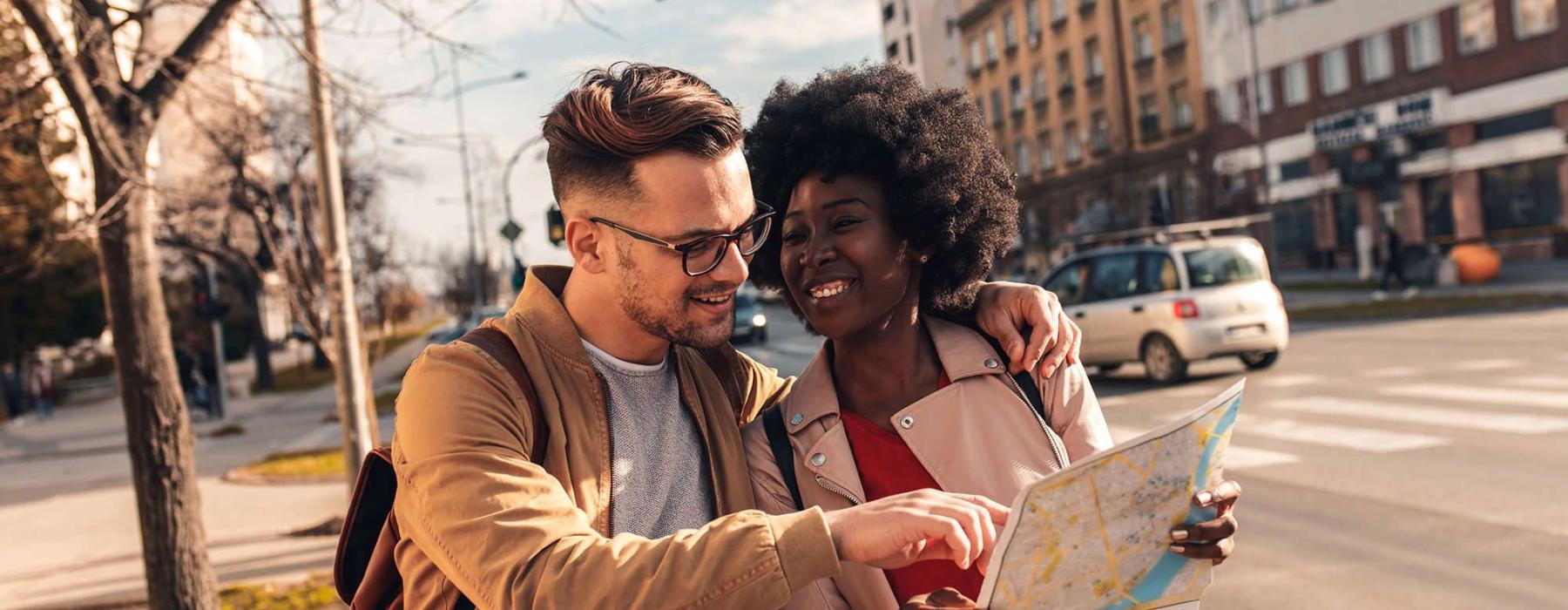 a man and woman looking at a map in the city