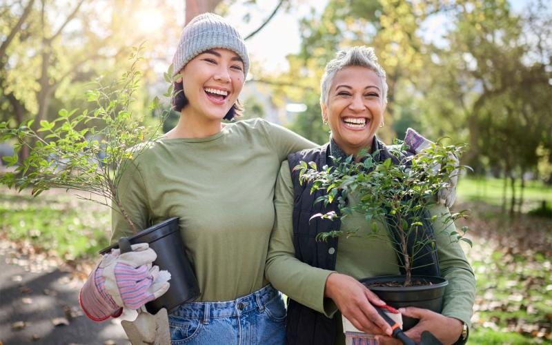 a couple of women holding plants