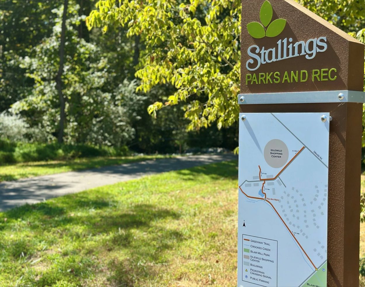 Trailhead sign and path at the Stallings Greenway